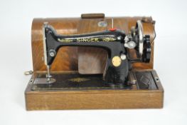 A vintage Singer sewing machine, Y8348183, the black body with gilt decoration and a winding handle,