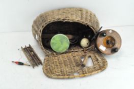 A vintage fishing basket,containing wooden reel, floats and hooks