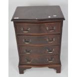 A reproduction serpentine front chest of drawers, covered in mahogany veneer,