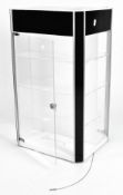 A modern perspex swivel display cabinet with three shelves and black and white panels,