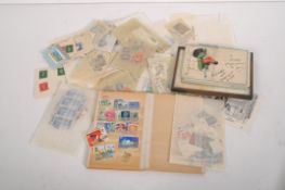 A miniature postcard album and a quantity of loose stamps of assorted designs and nationalities,