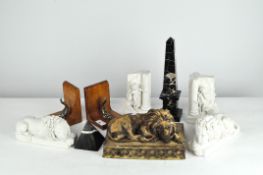 Two pairs of bookends together with three models of reclining lions, a stone obelisk and a pyramid