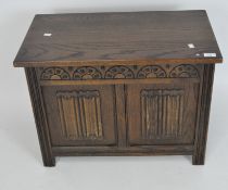A reproduction oak blanket chest of small size, the front carved with linen fold and half circles,
