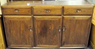 A dark wood Ercol sideboard with three drawers over three cupboards with shelves,