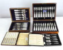 A set of silver fish forks together with three boxes of plated cutlery, and a canteen