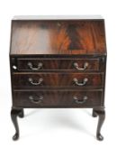 A mahogany bureau with pigeon holes and small drawers behind the fall, above three drawers,