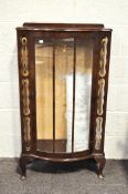 An Art Deco glazed display cabinet, of curved outline, gilt with a star to the front,