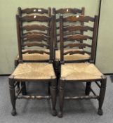 A set of four 19th century elm ladder back chairs with rush seats and turned legs on bun feet,