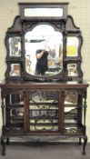 An Edwardian fretwork display cabinet inset with bevelled edge mirrors of varying shapes and sizes,