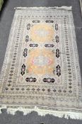 A Persian style rug with cream, black and raspberry coloured geometric panels,