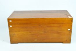 A flat-topped, stained wood blanket chest with wood handles to the sides,