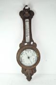 A early 20th Century oak cased banjo aneroid barometer, with thermometer to stem,