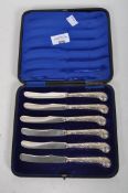 A boxed set of hallmarked silver pistol grip butter knives,
