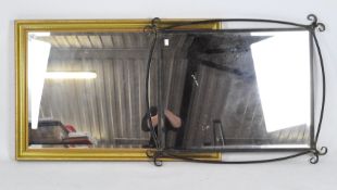 Two contemporary rectangular bevelled edge wall mirrors, one with gold and black metal frame,