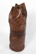 A contemporary antique style brown leather punch bag with brass hanging chain,