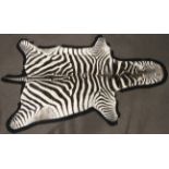 A zebra hide mounted on black felt backing,