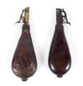 Two 19th century leather-mounted shot flasks, one tooled with a hare and game with brass mounts,