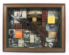 A sporting collage, including a shotgun stock, cartridges, photos, cartridge boxes and other items,