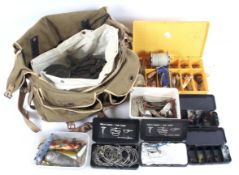 A canvas tackle bag with contents including sea fishing weights and boxes of Trout flies and