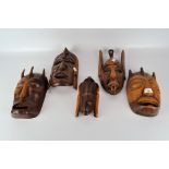 A collection of 1940's carved wooden masks, of assorted designs and sizes,