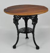 A pub table with wood top on a black painted cast iron tripod support,
