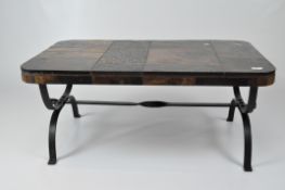 A vintage heavy coffee table, the top of variously coloured slate tiles and gilt metal detailing,