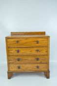 A contemporary chest of drawers, four long drawers with metal handles, on raised feet,