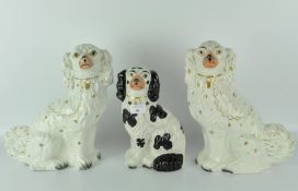 A pair of Staffordshire spaniels, glazed in white with gilt collars and details,