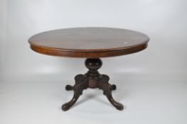 A Victorian mahogany loo table, the oval top raised on a central column,