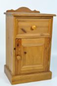 A modern pine galleried bedside cabinet with a drawer over a cupboard,