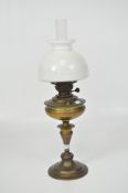 A vintage brass oil lamp, with circular base and white glass dome,