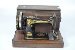 An 1897 Singer sewing machine in black enamel with gilt decoration, serial number 14682297,