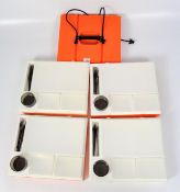 A vintage picnic box in orange and white, constructed of four fitted levels,