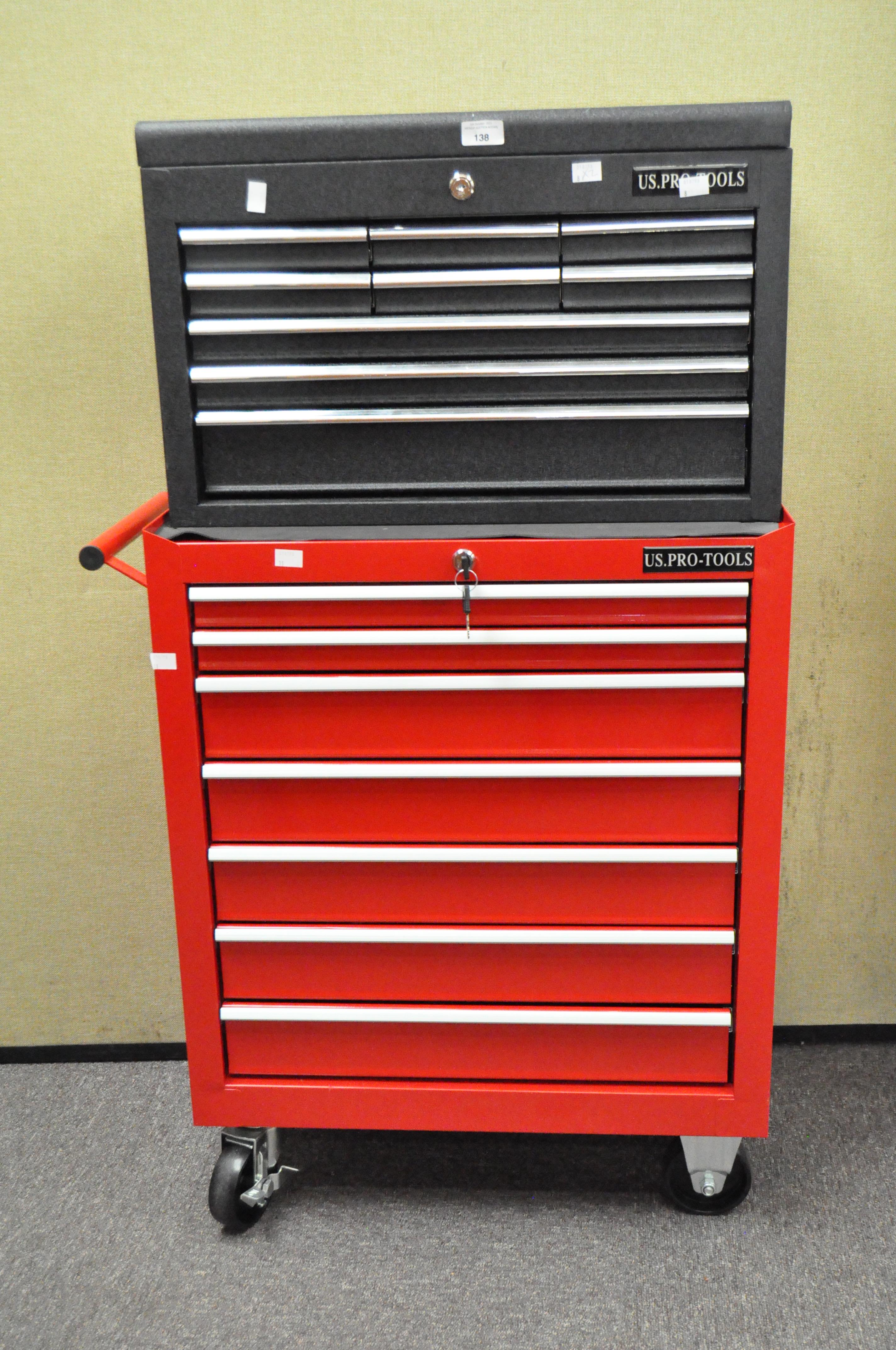 A red metal tool storage unit, with handle to one side, raised on wheels,