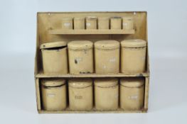 A vintage set of cream enamel metal storage tins, of two sizes in a matching hanging wall unit,