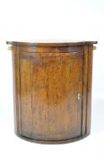 A 19th century oak bow fronted corner cupboard with one curved shelf, lock with key,