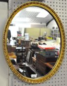 A modern oval mirror with moulded gilt frame,
