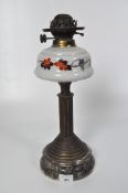 A Victorian oil lamp, glass reservoir painted with vines, supported by a gilt column stand,