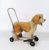 A Lines Bros push along dog on a red enamelled frame, with footrests and chrome handle,