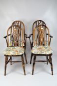 Two Victorian wheelback Windsor chairs, raised on turned legs and stretchers,