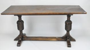 An antique oak refectory table, with a two plank top over carved cup and cover supports,