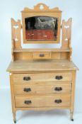 A Victorian pine dressing table with swing mirror suspended between pierced supports,