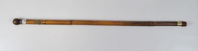 A 20th century military stick, bamboo with the badge of the Royal Irish Regiment attached,