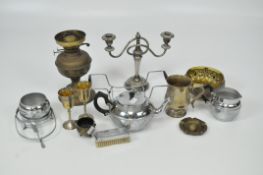 An assortment of metalware, including an oil lamp, candlestick, two glasses,