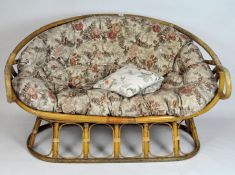A conservatory bamboo sofa, with upholstered floral cushions,