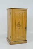 A faux pine pot cupboard with black painted details and one shelf,