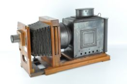 An antique magic lantern projector, the metal body mounted onto a wooden frame,