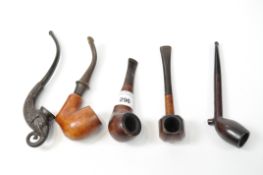 A collection of five tobacco pipes, some of walnut,