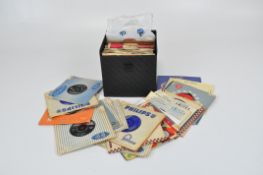 A box of singles records, containing a range of music,