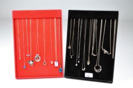 A selection of mostly silver necklaces and chains, some with hanging pendants,